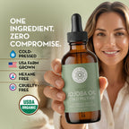Woman holding organic jojoba oil bottle highlighting cold-pressed, USA farm grown, hexane-free, and cruelty-free features.
