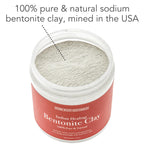 A jar of Bentonite Indian Healing Clay, 100% Pure is open, showing the light grey clay powder inside. The label states "100% pure & natural sodium bentonite clay, mined in the USA." Text on the jar highlights its benefits for detox and skin improvement.