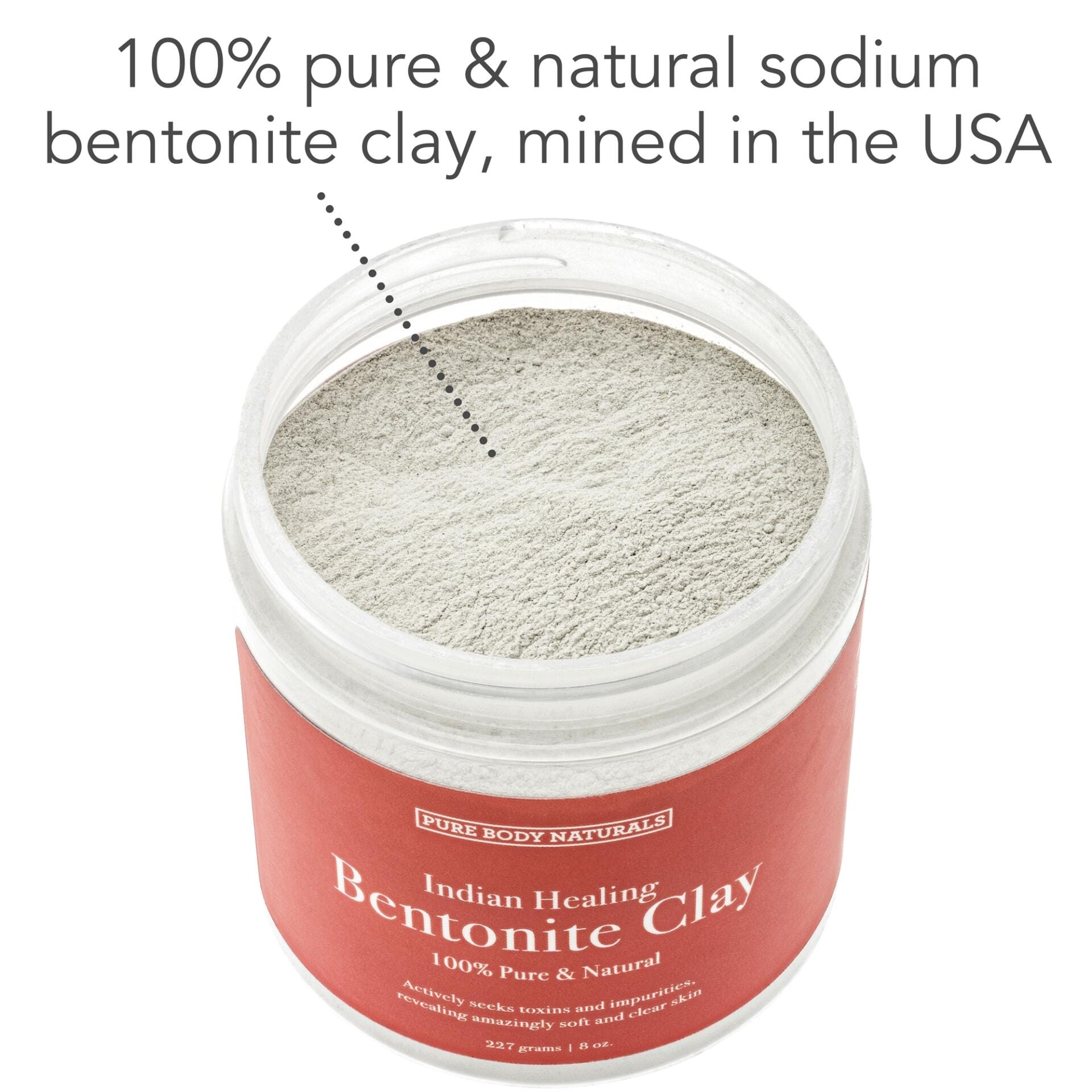 A jar of Bentonite Indian Healing Clay, 100% Pure is open, showing the light grey clay powder inside. The label states "100% pure & natural sodium bentonite clay, mined in the USA." Text on the jar highlights its benefits for detox and skin improvement.
