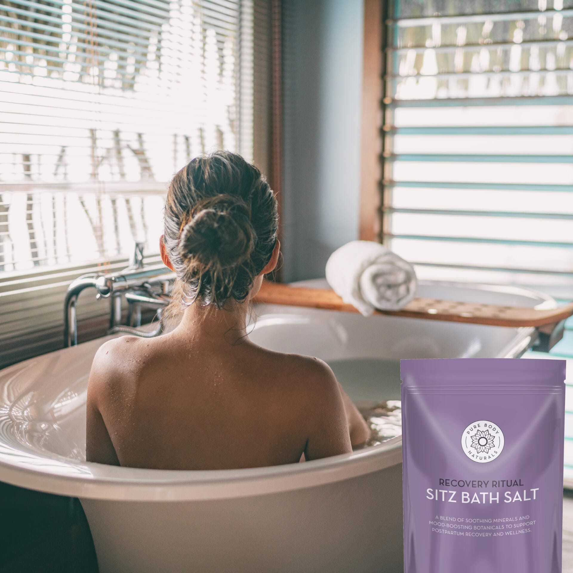 Person in a bathtub with a package of Sitz Bath Salt in the foreground