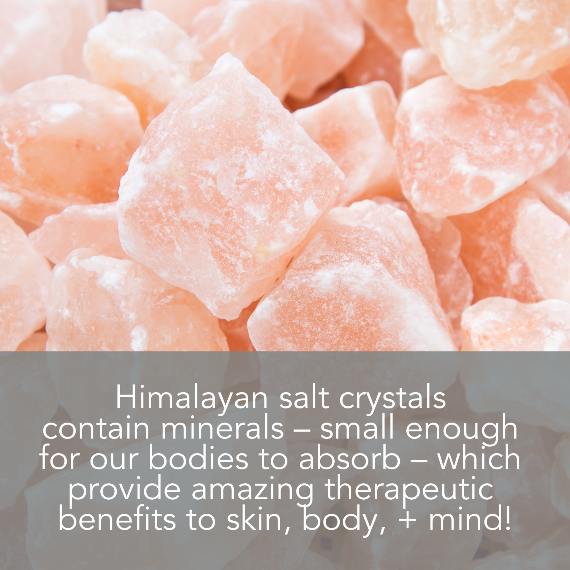 Close-up of pink Himalayan salt crystals with a text overlay that reads: "Himalayan Pink Salt Exfoliating Scrub contains minerals – small enough for our bodies to absorb – which provide amazing therapeutic benefits to skin, body, + mind!.