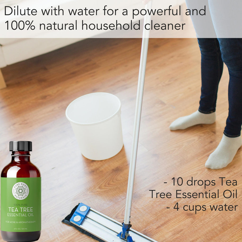 A person is mopping a wooden floor next to a white bucket. A bottle of Tea Tree Essential Oil, 4 fl oz is shown in the foreground. The text reads: "Dilute with water for a powerful and 100% natural household cleaner. - 10 drops Tea Tree Essential Oil, 4 fl oz - 4 cups water.