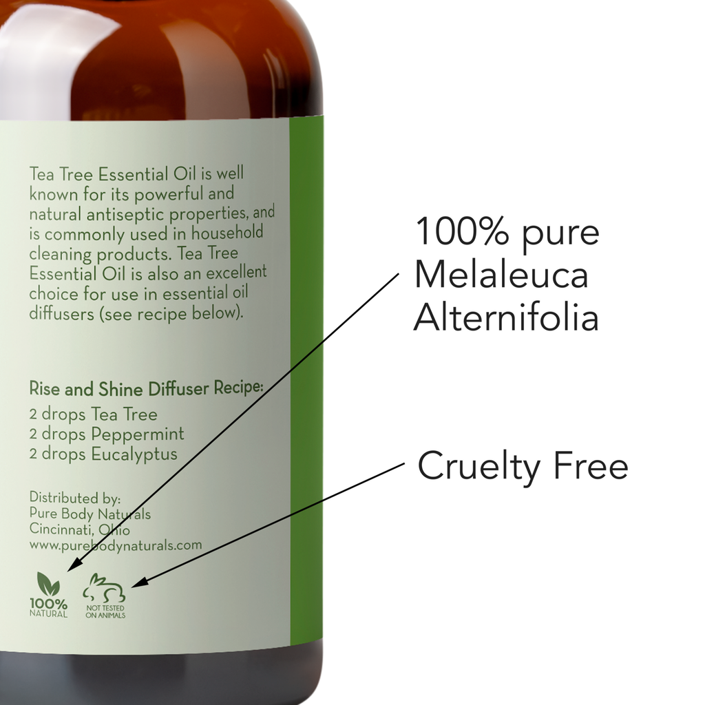 A close-up of a green and brown essential oil bottle. The label reads "Tea Tree Essential Oil, 1 fl oz," describing its antiseptic properties. It provides a diffuser recipe and states the product is "100% pure," "Cruelty Free," and distributed by Pure Body Naturals in Cincinnati, Ohio.