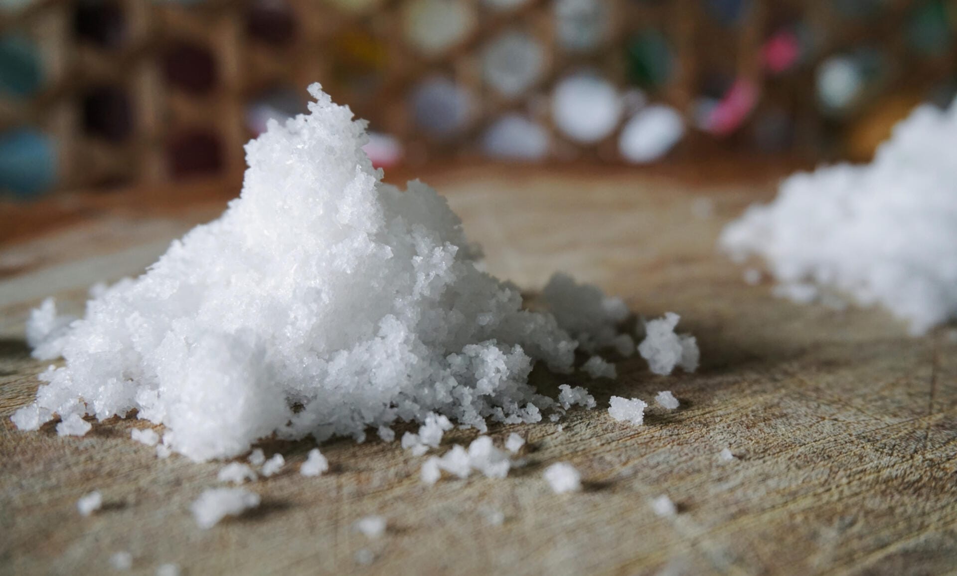 White granulated sugar on a wooden surface with a blurred background