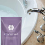 Purple package of 'Recovery Ritual Sitz Bath Salt' next to a sink.
