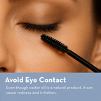 Close-up of mascara wand near eye with text about castor oil use.