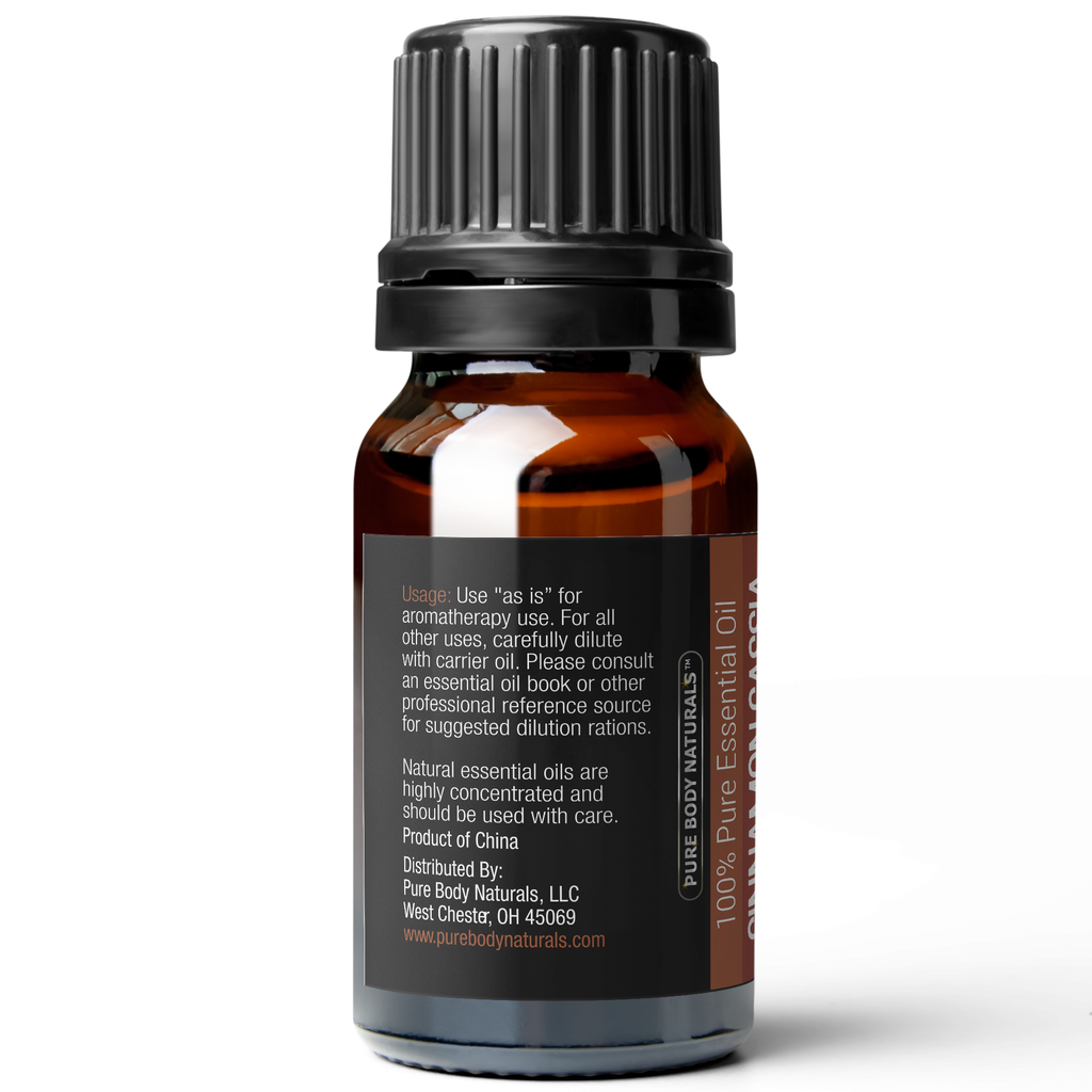 A dark amber glass bottle of Cinnamon Cassia Essential Oil, 10 ml with a black screw cap. The label includes usage instructions, dilution recommendations, and distributor information, with a note that the product is made in China.