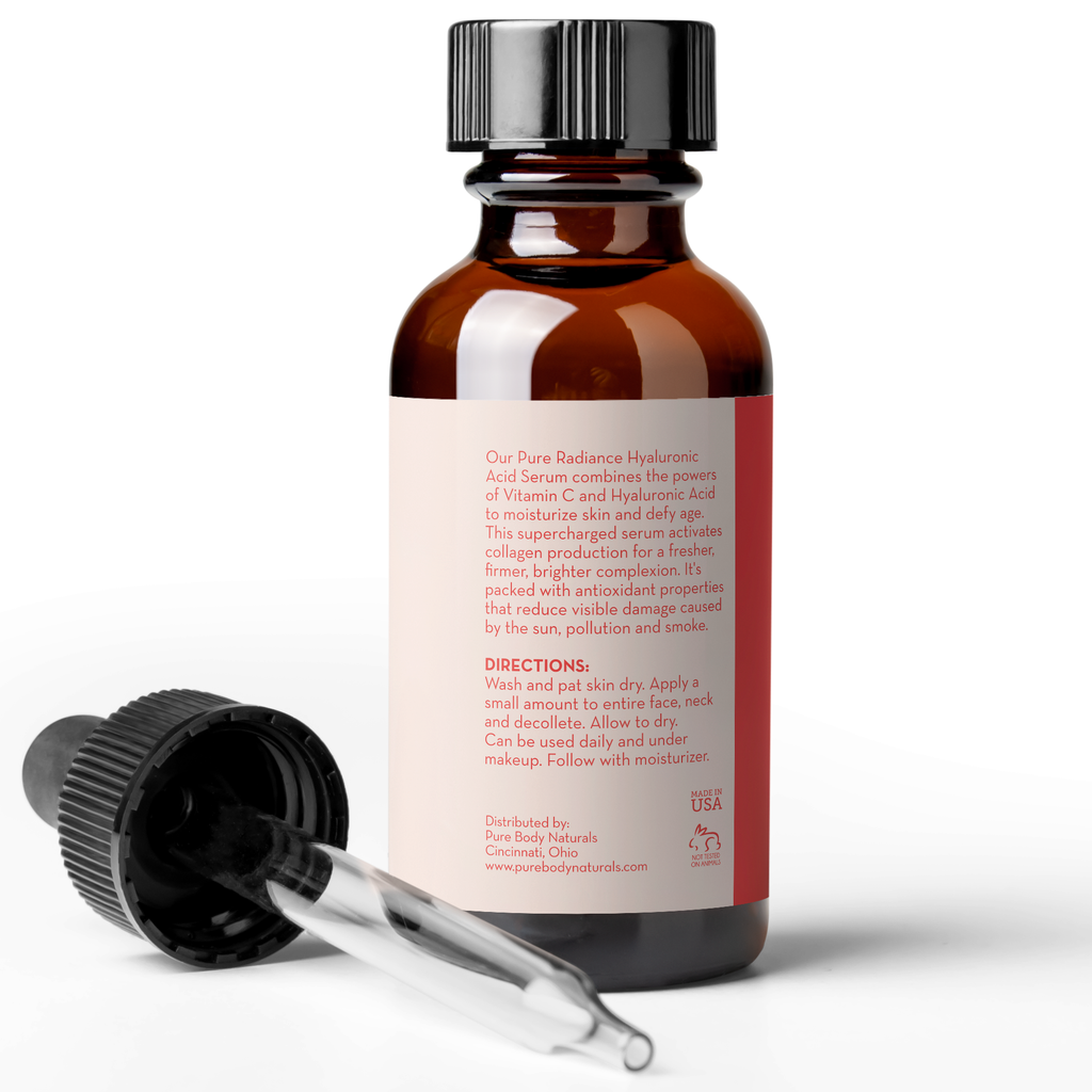A brown glass bottle with a black dropper cap is next to a dropper laying on its side. The bottle's label provides product information, stating it is an Age Defying Hyaluronic Acid Serum with Vitamins C & E, 1 Fl Ounce with directions for use. The dropper contains a clear liquid.