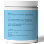 A white jar with a blue label displays usage instructions for Kaolin Clay Powder, 100 g. The directions detail a recipe combining kaolin clay, aloe gel, water, and essential oil, to be applied and rinsed off after 5 minutes. The jar includes ingredients and caution information.