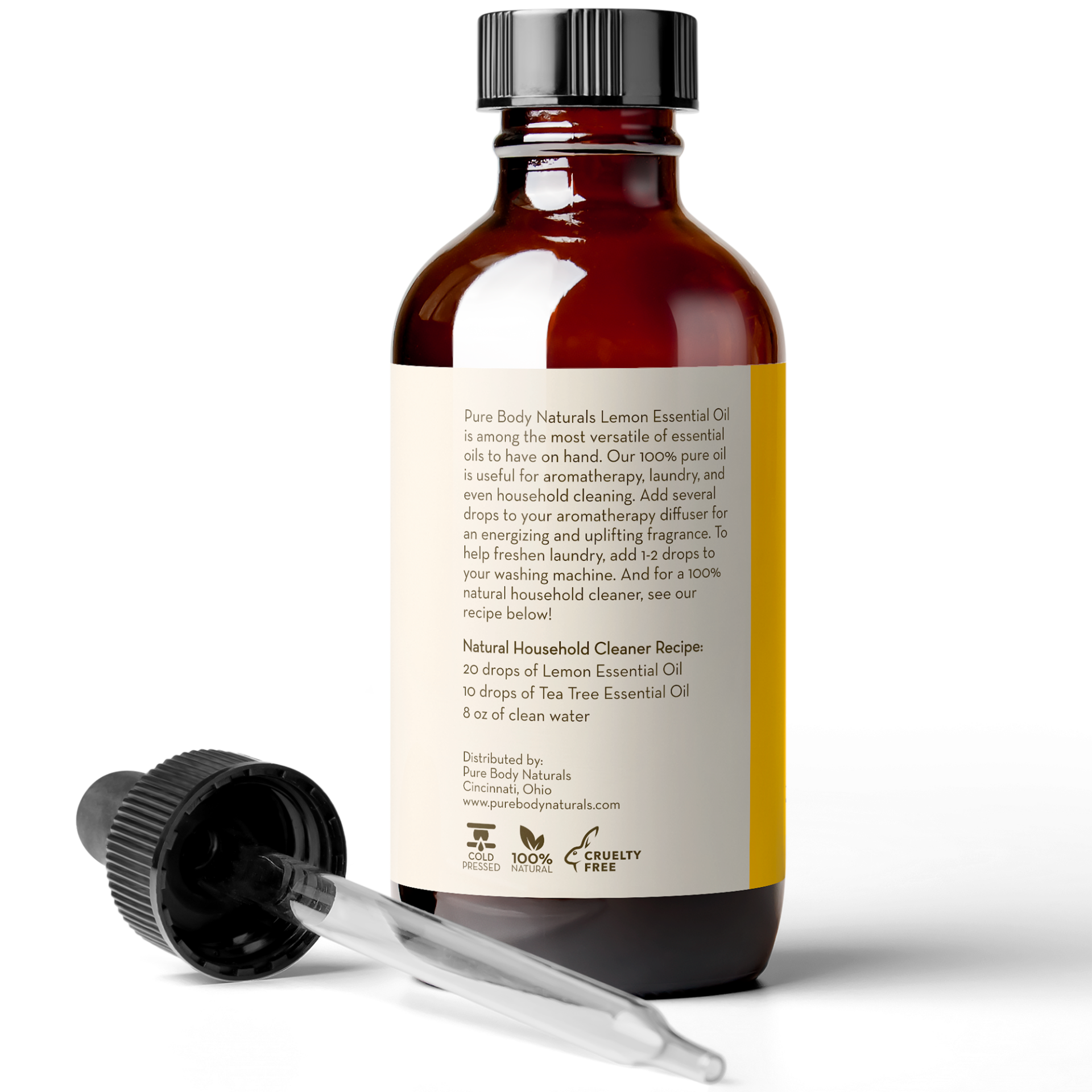 A brown bottle labeled "Lemon Essential Oil, 4 fl oz" stands against a white background. A black dropper with a clear pipette rests beside the bottle. The label includes text about the product and a recipe for a natural household cleaner.