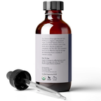 The image shows a brown bottle with a label that reads "Cold Pressed Tamanu Oil" and an eyedropper beside it. The label details that the oil is organic, virgin, and unrefined Tamanu Oil, explains its benefits, and gives usage instructions.