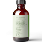 A brown glass bottle with a black cap contains Tea Tree Essential Oil, 4 fl oz. The label provides information about its antiseptic properties and usage in household cleaning products. An air-purifying diffuser recipe is included: 2 drops each of Tea Tree, Peppermint, and Eucalyptus oils.