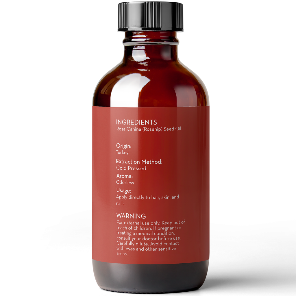 A brown bottle with a black cap displays a label on the front. The label lists ingredients (Rosa Canina (Rosehip) Seed Oil), origin (Turkey), extraction method (cold pressed), aroma (odorless), usage instructions, and a warning for external use only. The product name is Rosehip Seed Oil, 4 fl oz.