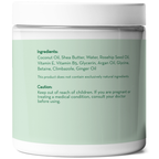 A white container with a light green label displays product information. The ingredients listed include coconut oil, shea butter, rosehip seed oil, among others. A caution advises keeping out of reach of children and consulting a doctor if pregnant or treating a medical condition. The product name is Coconut Oil Intensive Repair Hair Mask.