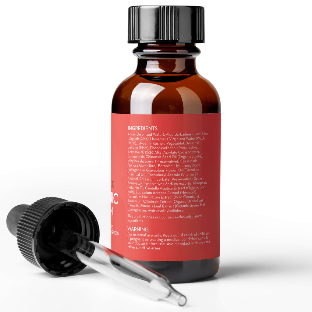 A brown glass bottle with a black screw cap lies next to a partially removed dropper. The red label on the bottle lists ingredients and warnings. The ingredients include various organic extracts and oils. The warning advises keeping out of reach of children. This is the Age Defying Hyaluronic Acid Serum with Vitamins C & E, 1 Fl Ounce.