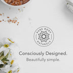 A ceramic bowl with pink Himalayan salt, a white towel, and white flowers are arranged around a logo that reads "Hair Gel for Men" with a flower design. Below the logo, text reads, "Consciously Designed. Beautifully simple.