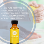 A bottle of Lemon Essential Oil is in the foreground. Behind it, someone is holding a slice of lemon. Text on the image reads, "100% Pure Essential Oil, Perfumery Note: Top, Extraction: Cold Pressed, Initial Aroma: Strong, Cruelty-Free Testing.