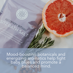 A package of "Recovery Ritual Sitz Bath Salt, 10 oz" is placed next to a sprig of rosemary and half a grapefruit. The packaging mentions its benefits, including mood-boosting botanicals and energizing aromatics to help balance the mind.