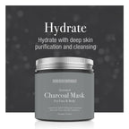 Gray jar of activated charcoal mask with silver lid on a dark background